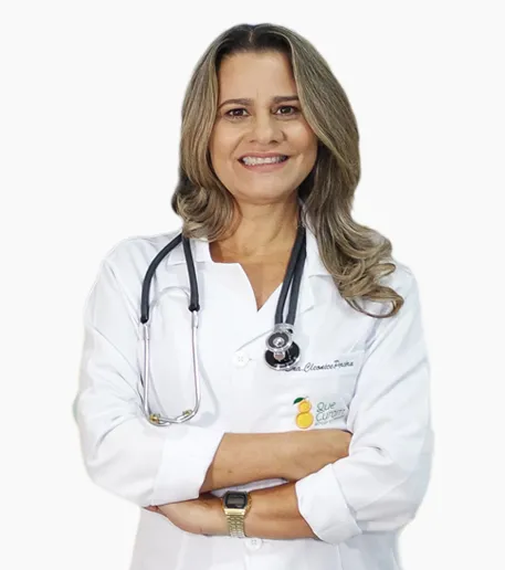 Dra. Cleonice Pereira segurando folhas verdes em meio a legumes